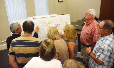 Sunshot by Michael Hall — A group of audience members gather during an executive session at the Sept. 9 Hartwell City Council meeting to learn details from consultant Shawn Davis, far left, of the proposed project to rethink Hart State Park. 