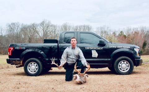 Sunshot by Grayson Williams — DNR Cpl. Craig Fulghum poses for a photo with a deer that was killed illegally.
