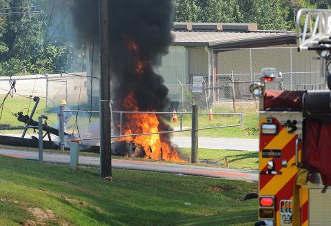 Sunshot by Michael Hall — A fire truck stands by while firefighters and police officers wait for power to be turned off to a burning power pole near Hart County High School on Tuesday. 