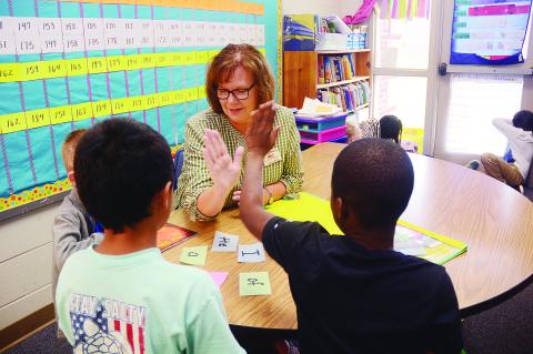 Sunshot by Michael Hall — Jenny Martin high-fives a second-grade student after he successfully identified a word in a reading exercise recently at Hartwell Elementary School. 
