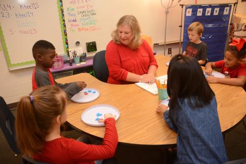 Sunshot by Michael Hall — Teacher Kathleen Teel, center, works with second-grade students recently at South Hart Elementary. 