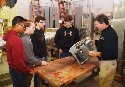 Sunshot by Michael Hall - McGee Heating and Air president Robert Kesler, right, talks to students at the Hart College and Career Academy this week about how a central HVAC system works. 