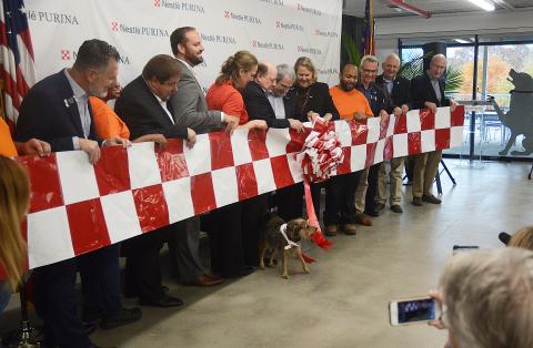 Sunshots by Michael Hall — City, county and state officials along with representatives from Nestlé-Purina watch as Mac, the dog, above, pulls the ribbon to mark the grand opening of the Hartwell pet-food production facility. 