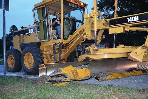 A Hart County road crew employee removes the speed bumps in Bowersville in August.