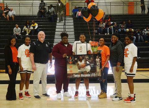 Sunshot by Michael Hall — Taniya Alexander, center, holds a poster and other items given to her to honor her for scoring 1,000 points for Hart County. Pictured are coach Joreshica Martin, Tanyzia Teasley, head coach Mike Edwards, Demardric Thornton, Alexander, her mother Tammy Scott, coach Dannette Bowers-Davis and Shakendra Grove. 