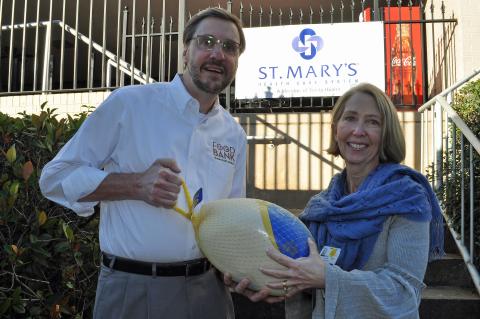 Photo submitted — Food Bank of Northeast Georgia Executive Director Chuck Toney, left, accepts a turkey from St. Mary’s Vice President of Mission Services Julie Carter. 