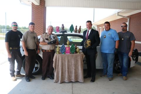 Sunshot from file — Hart County Sheriff Mike Cleveland, to the left of the table, and District Attorney Parks White, to the right of the table, pose for a photo earlier this year with deputies and a large amount of methamphetamine that had been formed in the shape of candles. 