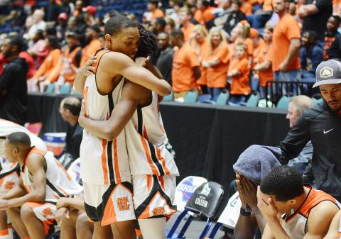 Sunshot from file — Hart County sophomore Shone Webb, left, consoles teammate, senior Elijah Robinson as time ticks down in the Bulldogs’ state championship loss in March in Macon as other teammates sit on the bench with heads in hands.