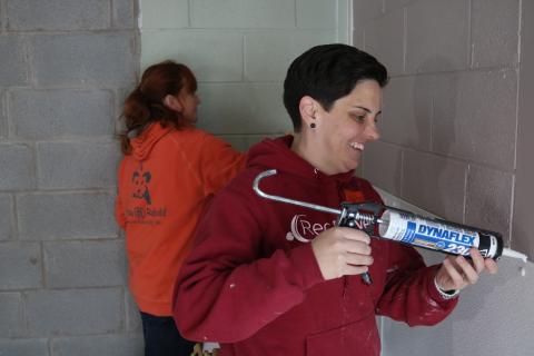 Sunshot by Grayson Williams — RedRover Outreach Manager Katie Campbell, right, and Bryna Donnelly, left, Director of GreaterGood.org’s Rescue Rebuild program, caulk and paint a new indoor kennel area at the Northeast Georgia Council on Domestic Violence’s shelter.
