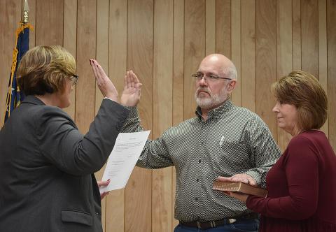 Sunshots by Michael Hall - Hart County Probate Court Judge Merry Kirk, left, conducts the swearing-in ceremony for Pruitt Manley, center, the new mayor of Bowersville, as his wife Lori Manley, right, holds the Bible.
