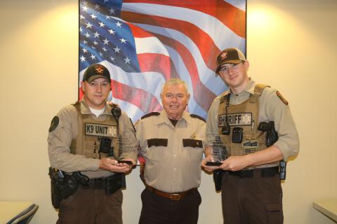 Sunshot by Grayson Williams - Hart County deputies Steve Williams, left, and Matt Sparrow, right, pose for a photo with special plaques presented to them by Hart County Sheriff Mike Cleveland, center, for saving a man’s life. 