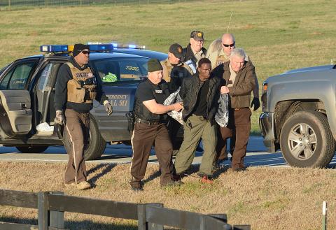 Sunshot by Michael Hall - Hart County Sheriff Mike Cleveland, right, and deputies escort Larrendrick Rashad Tabor, center, from a squad car to an ambulance after his arrest Tuesday, Jan. 28, for his alleged involvement in a Monday night murder in Hart County. 