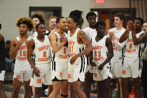 Sunshots by Grayson Williams - Junior Shone Webb, No. 21, is all smiles as he shakes hands with Demetrius Glenn, No. 0, as his Bulldog teammates congratulate him on scoring his 1,000th point for Hart County. 