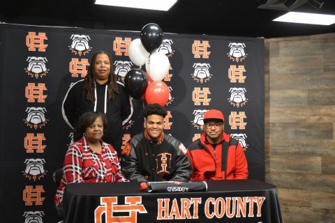 Sunshot by Drew Dotson - Hart County defensive lineman JT Hunt, center, poses for a photo after signing with his father Ronnie Hunt, right, brother Marco Hunt, standing, and mother Jennifer Hunt.