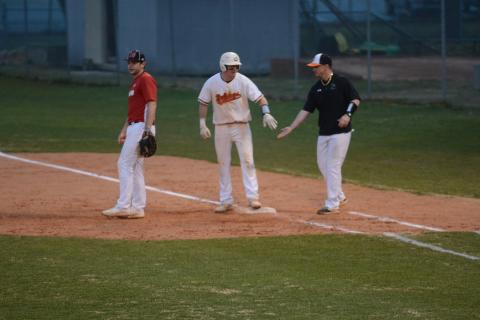 Luke Lee, left, is congratulated by coach Hunter Barton, at first base after Lee’s line drive that drove in a run to take the lead against Morgan County on Monday at Saye Field. 
