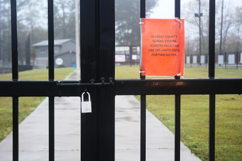 The gate at Saye Field at Hart County High School is locked with a note about the grounds being off limits.