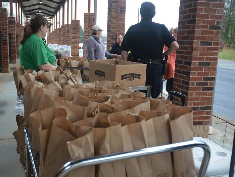 A cart full of prepared bagged lunches wait to be passed out to families as part of a program through the Hart County Charter System to provide lunches during the school closure due to the coronavirus pandemic. 