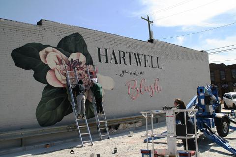 University of Georgia art students Katie Eidson, Alondra Arevalo and Rina Yoo work on a mural on the side of Blush Hair Studio in downtown Hartwell.