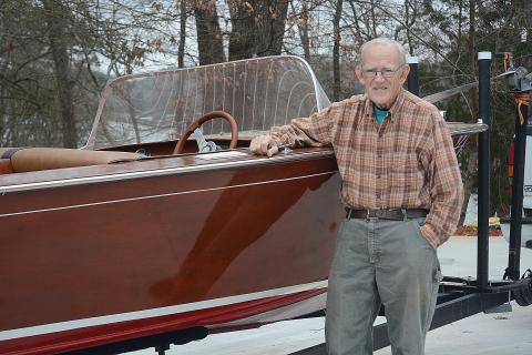 Sunshots by Michael Hall -  Lee Mapp poses for a photo next to his Correct Craft classic boat. 