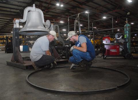 Sunshot from file — Fabritex metal fabricators Martin Neal, left, and Jon Grubbs, right, layout the wheel at Fabritex in 2018 that is now part of a mechanisim used to ring the Victory Bell at Hart County High School. The company refurbished the bell and renewed a longstanding tradition for Hart County Schools, one of many ways Fabritex partners with local schools. 