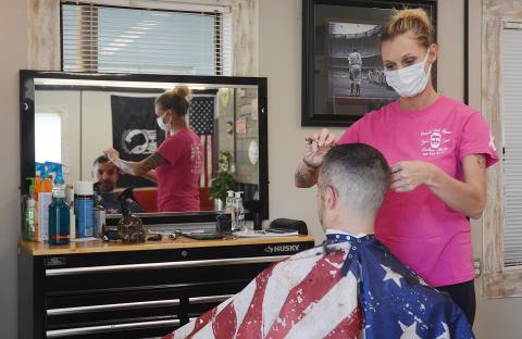 Sunshot by Michael Hall — Beards and Shears Barbershop owner, Julie Thomas, cuts the hair of Clint Bridges last Friday, April 24, on the first day she was allowed to open again following a closure due to the COVID-19 pandemic.