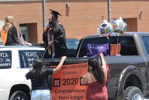 Sunshots by Michael Hall Maria Rangel talks with another graduate as her family helps her hang a banner from the back of a truck prior to the Parade of Graduates on May 23 in Hartwell. 