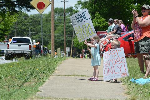 Violet Ayers, left, 6, and Jasper Ayers, 4, right, hold signs in support of their cousin Emma Ayers on Saturday, May 23, during the Parade of Graduates in Hartwell. — Sunshot by Michael Hall