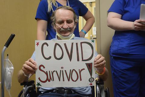 Sunshot by Michael Hall — Richard Frady holds a sign identifying himself as a COVID-19 survivor. 