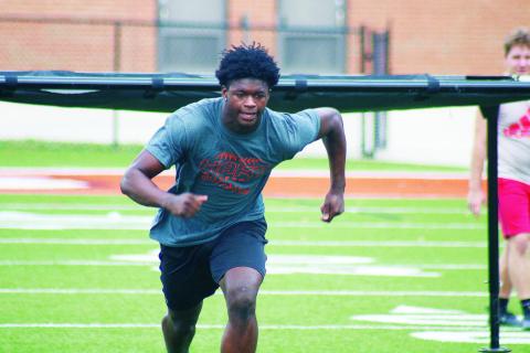 Senior running back Malachi Thomas darts out of the shoot during a drill on Monday.