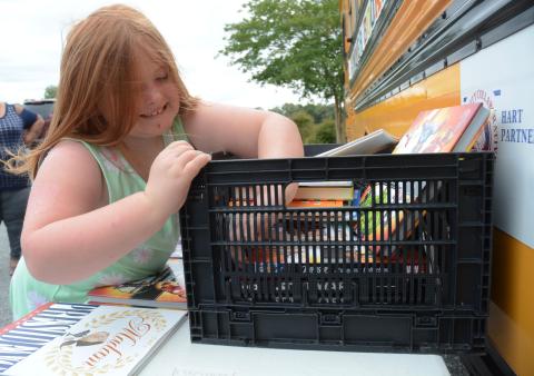 Photo from file — Emily Pickens, 7, finds a Star Wars book Tuesday, June 16, during a stop of the Hart Partners Summer Book Mobile at the Reed Creek Dollar General, for her brother Ethan, 11. 