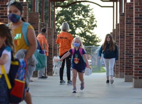 Sunshot by Michael Hall — Danica Kerr, middle, a first-grade student at Hartwell Elementary, runs to class after being dropped off at the school on Monday, Aug. 17 for the first day of the 2020-2021 academic year.