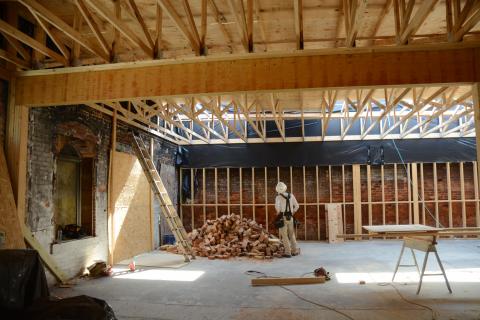 Sunshot by Michael Hall — A construction worker with J. Davis Construction stands inside the ongoing renovations at Little Japan in downtown Hartwell a year after the restaurant burned. 