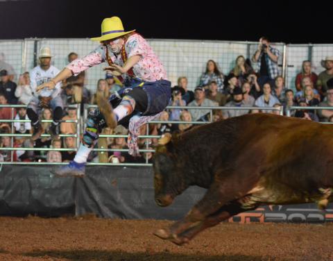 Justin Josey, of Apache, Okla., jumps over a charging bull as it bursts out of the gate.