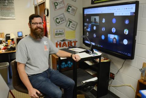 Sunshot by MIchael Hall - Josh McCurley poses for a photo at his virtual learning station where he is teaching third-grade virtual learners and will use a Bright Ideas Grant from Hart EMC to teach them circuitry. 