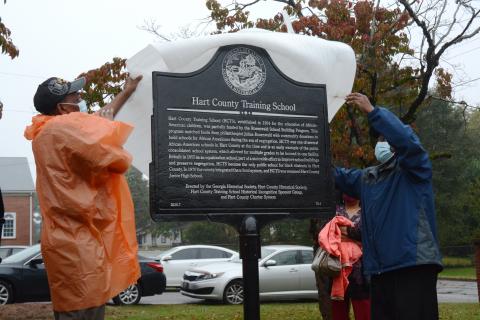 Sunshot by Michael Hall - Thomas Morrison, left, and Michael Partlow, right, unveil the new historical marker from the Georgia Historical Society at the former Hart County Training School on Richardson Street on Oct. 10. 