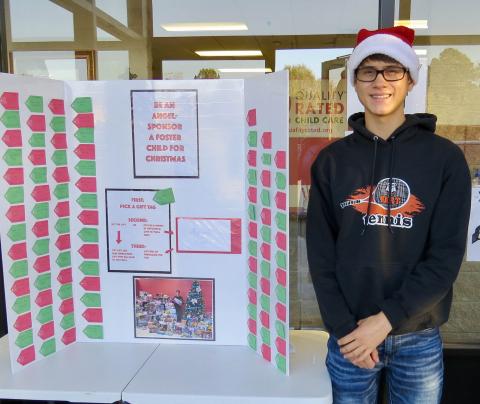 Photo submitted  - Ben Tellano poses for a photo with the Angel Tree display at the Bell Family YMCA recently. 