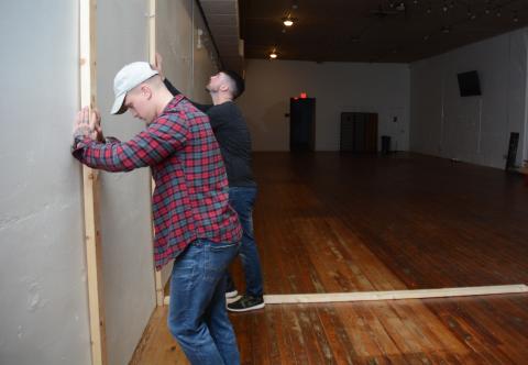 Sunshot by Michael Hall - Andrew Whitworth, left, and business partner Austin Gentry, right, stand lumber up against a wall in the Howell Street building where Sublime Axe Throwing is set to open to show the dimensions of a lane. 