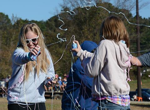 Brooklyn Vassar, left, and Mia Dancause, right, both fifth-graders, duel with cans of silly string during the Silly String Club Day activity. 