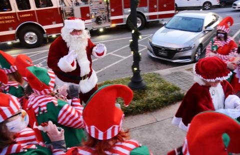 Santa waves to his elves as they greet him and Mrs. Claus, who hitched a ride to the event with the Hartwell Fire Department. 