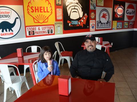 Omar Vega, right, and his daughter, Anna Blazek, left, sit in the newly remodeled Scoops by Rolling Chefs. 