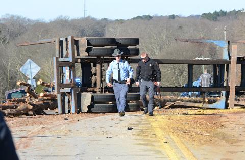 Sunshot by Michael Hall - Georgia State Troopers examine the scene of a log-truck crash on Thursday, March 4, that killed a Royston man.