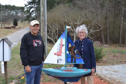 Sunshot by Drew Dotson - Frank, left, and Sandra, right, Spenger pose for a photo with a sailboat honoring the memory of Frank’s family restaurant, Spenger’s Fish Grotto. 
