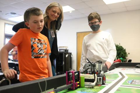 Grayson Williams/The Hartwell Sun South Hart Mindtwister team members Easton Kelley, left, and River Powell, right, eye their robot named “Robie” as it performs a task  and coach Tonya Bridges, center, watches on Thursday, April 22 at South Hart Elementary School.