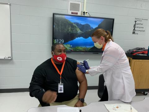 Photo submitted - Ruth Daniel, a volunteer for the Hart County Health Department, right, administers Johnson & Johnson’s COVID-19 vaccine to Hart County Middle School Assistant Principal Earl Fouch, left, during the school system’s vaccine clinic day.
