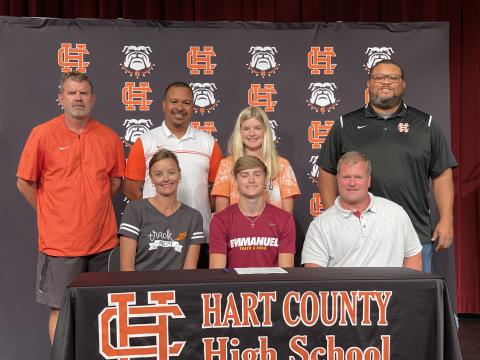 Photo submitted Chandler Smith, seated center, signed to Emmanuel College’s track team alongside, seated left, mother Tina Miller, seated right, stepfather Blake Miller, standing from left, coach Taz Dixon, coach Floyd Ramsey, sister Erin Miller and coach Kendell Rucker.