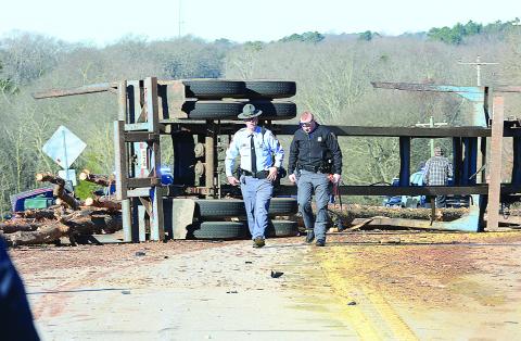 Sunshot by Michael Hall - Georgia State Troopers examine the scene of a log-truck crash on Thursday, March 4, that killed a Royston man.