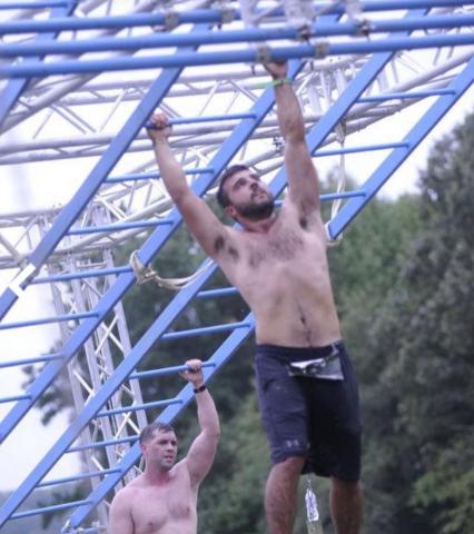 Buchanan traverses the monkey bars on an obstacle course.