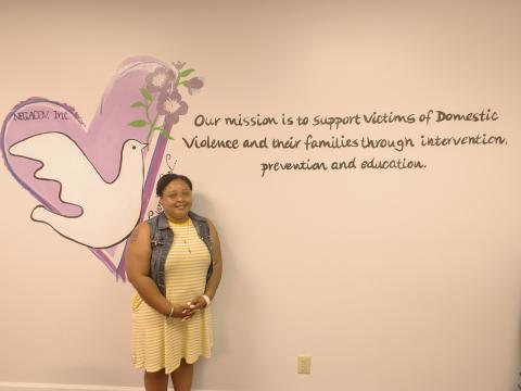 Dan Hunt/The Hartwell Sun - Sequilyous Mclendon, senior care advocate, poses in front of the mission statement at the Northeast Georgia Council on Domestic Violence.