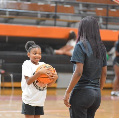  Dakota Wiley receives instruction from rising senior basketball player Kiyasia Montgomery. 