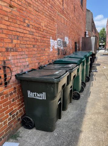 Drew Dotson/The Hartwell Sun - Trash cans line the walls of the alley shared by downtown businesses.